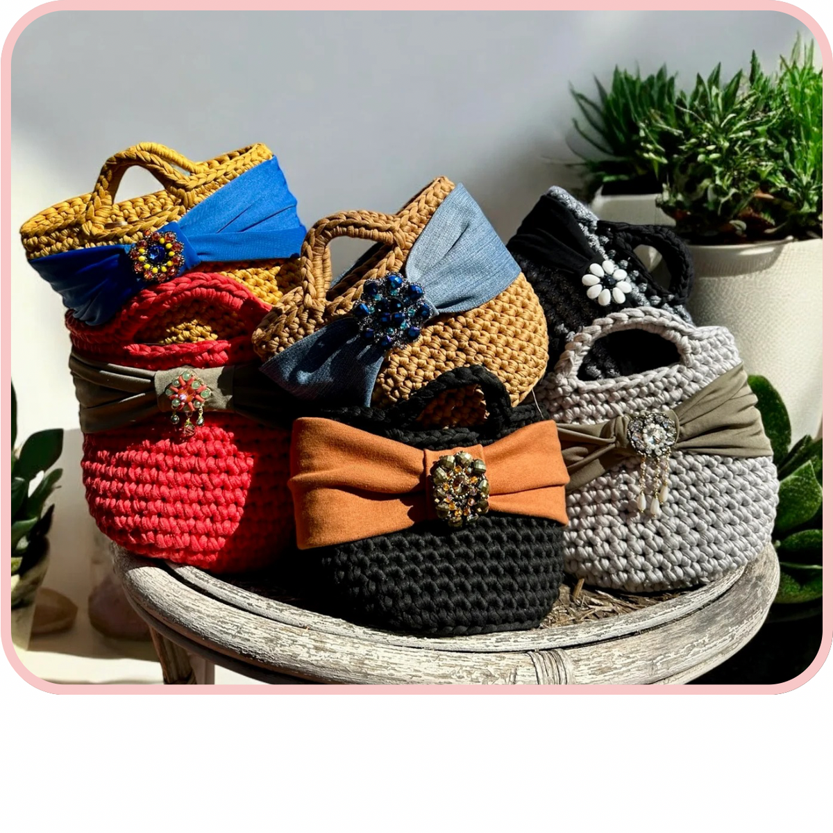 Colorful collection of stylish borse displayed on a wooden table, featuring unique designs and embellishments.