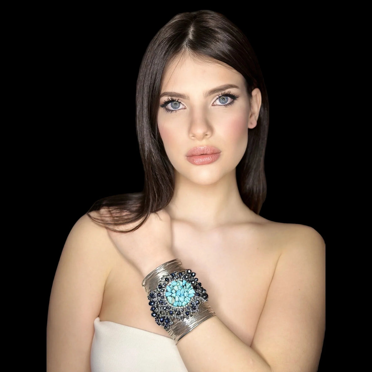 Bracciali: eleganti bracciali con dettagli blu indossati da una modella con pelle chiara e labbra nude.