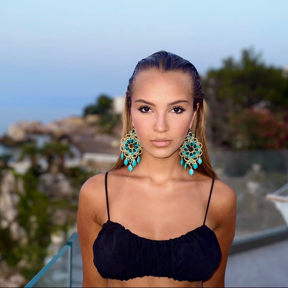 Modella con orecchini pendenti colorati, collezione orecchini pendenti, bellezza e stile eleganti.