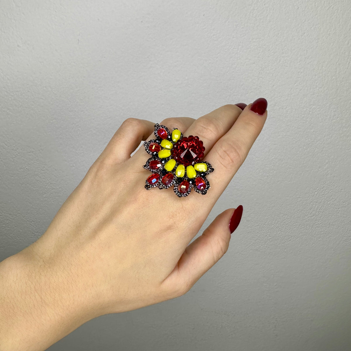 Anello Fiammetta indossato, con cristalli rossi e gialli, design elegante e creativo, Made in Italy.