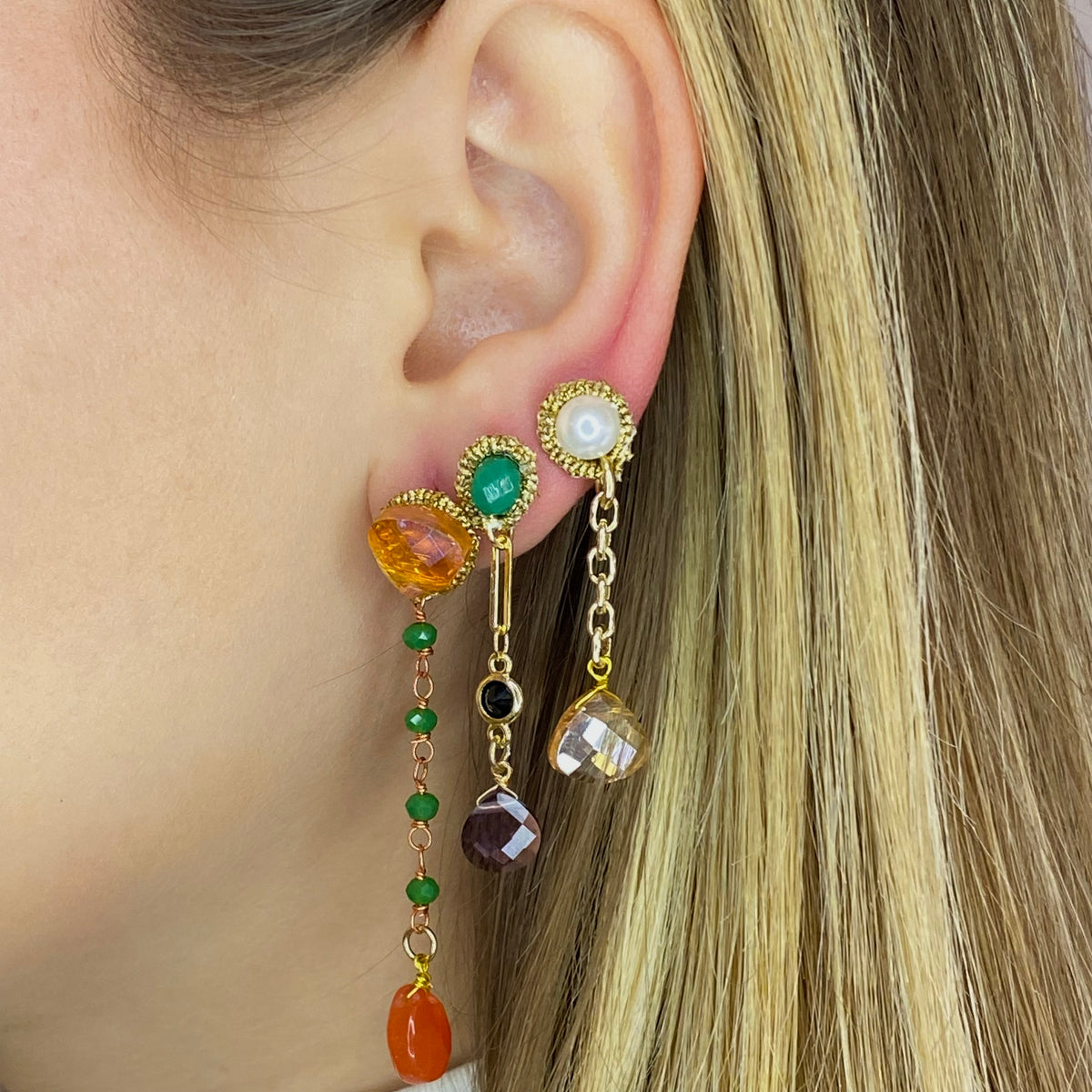 Orecchini Mono Pendenti with colorful gemstones and gold chains hanging elegantly from the ear.