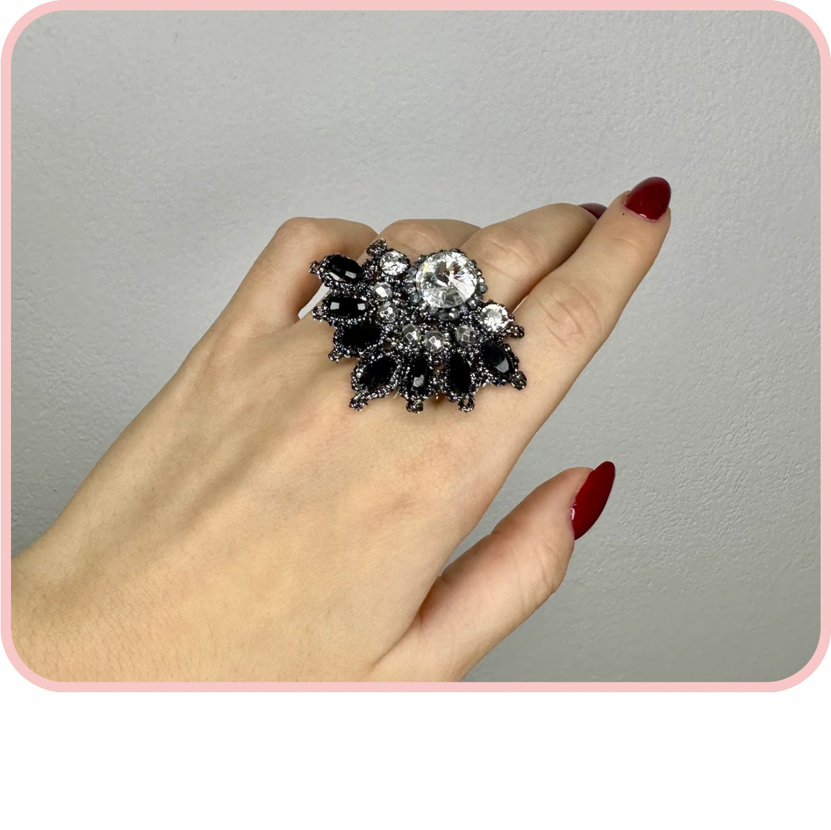 Anelli - Spring New Collection: a hand wearing an elegant black and silver statement ring.