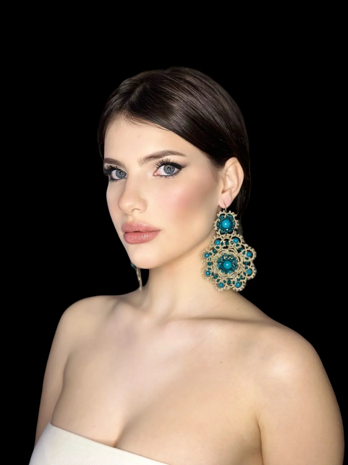 Modella che indossa orecchini eleganti in un'immagine suggestiva per Tutti Gli Orecchini.
